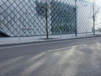 a building with large glass blocks and a tree in front of it on the side of the street