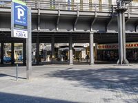 a large street with cars in it and people walking around and on the sidewalk in front of the entrance