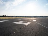 a small plane is parked in a runway at an airport with the sun behind it