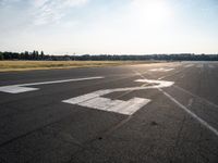 a small plane is parked in a runway at an airport with the sun behind it