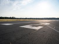 a small plane is parked in a runway at an airport with the sun behind it