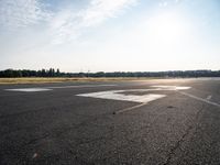 a small plane is parked in a runway at an airport with the sun behind it