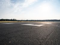 a small plane is parked in a runway at an airport with the sun behind it