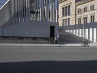 a person is riding a bike in front of a building with a ramp behind them