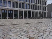 a brick building with glass windows and sidewalk leading to it and a black fire hydrant