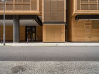 an empty street in front of a building with shuttered doors and windows that allow air parking and access