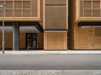 an empty street in front of a building with shuttered doors and windows that allow air parking and access