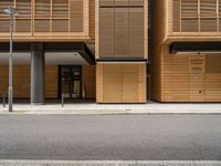 an empty street in front of a building with shuttered doors and windows that allow air parking and access