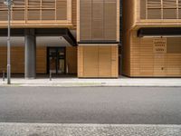 an empty street in front of a building with shuttered doors and windows that allow air parking and access