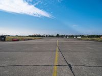 an empty air port and an airport runway on a sunny day with many traffic barriers