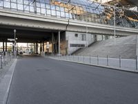 the parking lot for an indoor gym building near a street, which contains a walkway and stairs