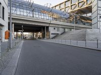 the parking lot for an indoor gym building near a street, which contains a walkway and stairs