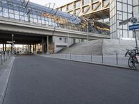 the parking lot for an indoor gym building near a street, which contains a walkway and stairs