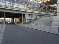 the parking lot for an indoor gym building near a street, which contains a walkway and stairs