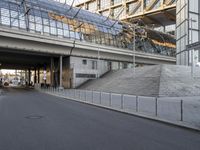 the parking lot for an indoor gym building near a street, which contains a walkway and stairs