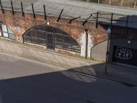 a picture of an old brick building with graffiti all over the top of it and some power lines across from it