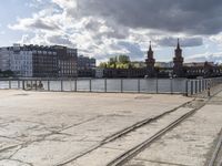 a river view looking at buildings near water and some tracks running beside the river edge