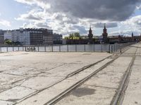 a river view looking at buildings near water and some tracks running beside the river edge