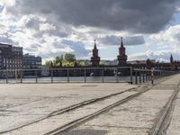 a river view looking at buildings near water and some tracks running beside the river edge