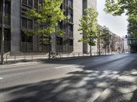 two parked bikes on the side of an empty street in city city area, near building