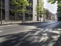 two parked bikes on the side of an empty street in city city area, near building