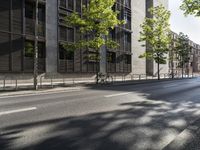 two parked bikes on the side of an empty street in city city area, near building