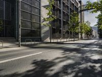 two parked bikes on the side of an empty street in city city area, near building