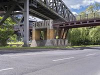 a street with an overpass crossing over water from a train bridge across the street