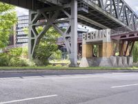 a street with an overpass crossing over water from a train bridge across the street