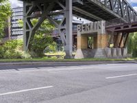 a street with an overpass crossing over water from a train bridge across the street