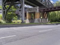 a street with an overpass crossing over water from a train bridge across the street