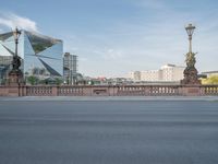 an empty city street next to a bridge and a tall building with tall buildings behind it