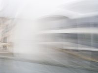 a blurry picture of a building from the water in a river area with one yellow umbrella