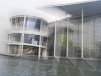 a blurry picture of a building from the water in a river area with one yellow umbrella