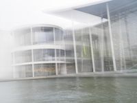 a blurry picture of a building from the water in a river area with one yellow umbrella