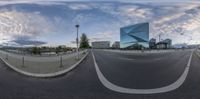 a view of an empty road near a modern building in a city setting with an upside down mirror