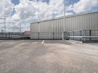 a parking lot with a metal fence and a long pole in the middle of it