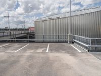 a parking lot with a metal fence and a long pole in the middle of it