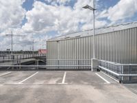 a parking lot with a metal fence and a long pole in the middle of it