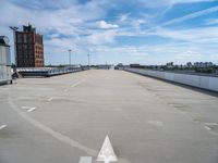 an empty parking lot is seen with two arrows on it's side and a building in the background