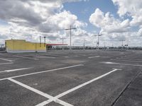 empty parking lot in a car park under a cloudy sky with white clouds above it