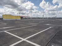 empty parking lot in a car park under a cloudy sky with white clouds above it