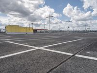 empty parking lot in a car park under a cloudy sky with white clouds above it