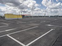 empty parking lot in a car park under a cloudy sky with white clouds above it