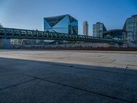 a skateboarder riding on a cement ramp next to a city street under a bridge