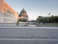 the city has many different buildings along the road in the back ground and a bridge in front