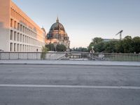 the city has many different buildings along the road in the back ground and a bridge in front