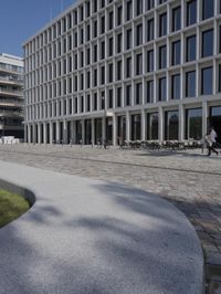 a brick building with glass windows and sidewalk leading to it and a black fire hydrant