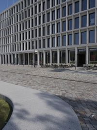 a brick building with glass windows and sidewalk leading to it and a black fire hydrant
