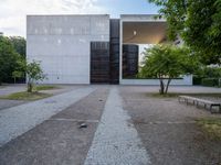 an empty walkway between a brick plaza and an open building on the ground at dusk